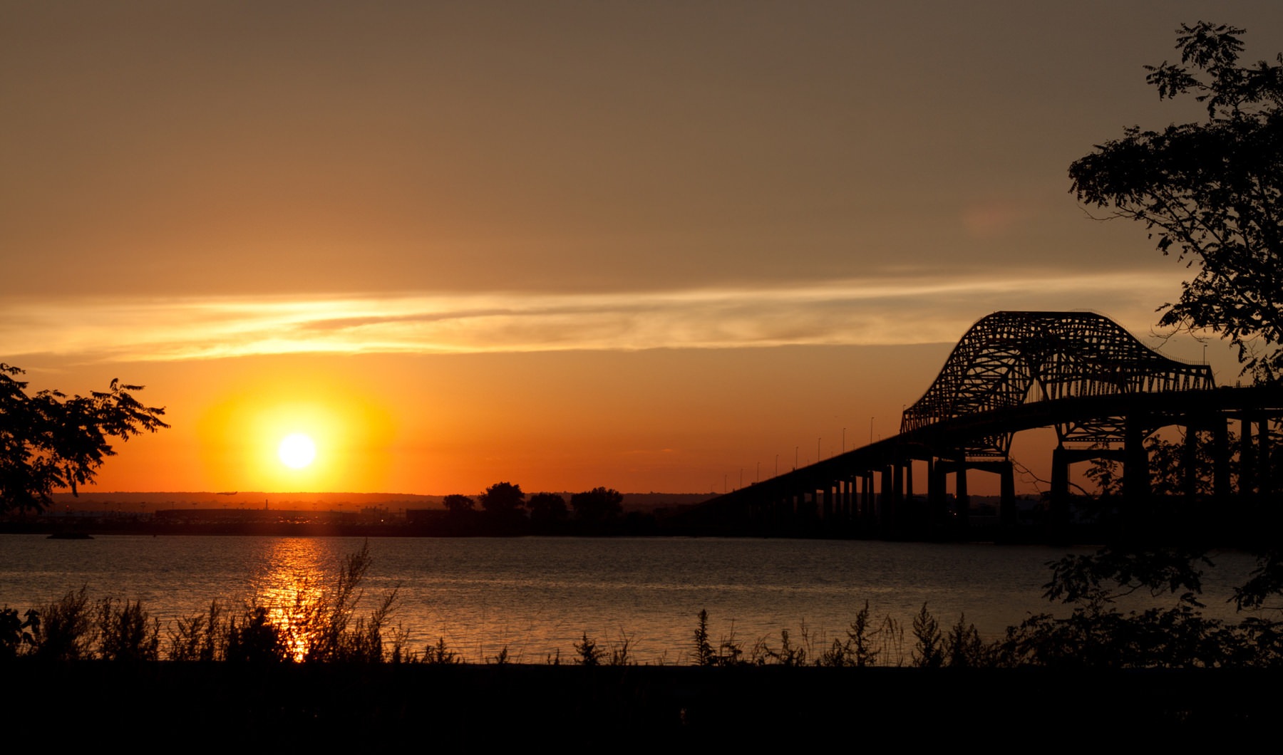 All Charm. All Access. sunset over lake with bridge